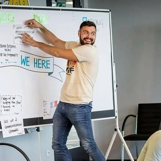 Nicolas Verdot, feutre en main, trace en direct sur un paperboard couvert de mots-clés et de pictogrammes